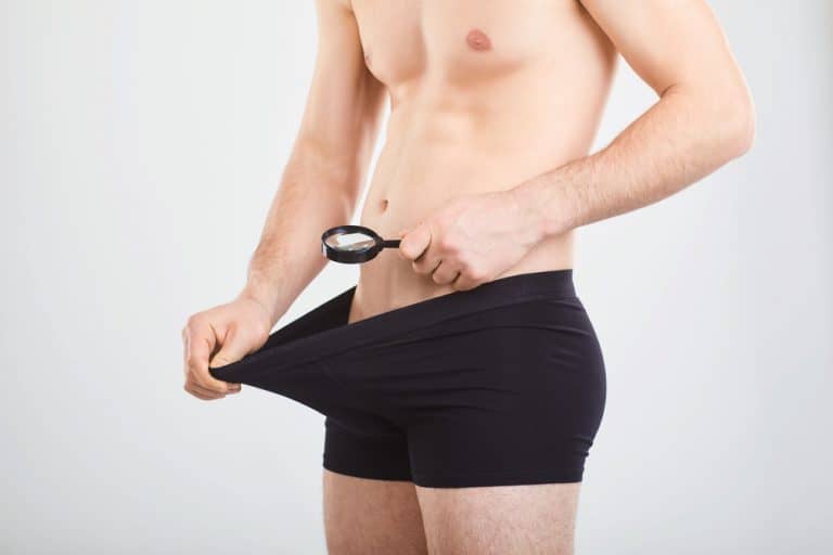 A man is looking at a penis with his magnifying glass